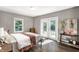 Bedroom features include hardwood floors, neutral walls, french doors to the backyard, and a large window at 6491 N Oxford St, Indianapolis, IN 46220