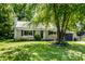 Charming single-story home with beautiful stone facade, manicured lawn, and mature shade tree at 6491 N Oxford St, Indianapolis, IN 46220