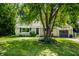 Charming single story home featuring a manicured lawn, gray garage, and a tree in the front yard at 6491 N Oxford St, Indianapolis, IN 46220