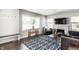Bright living room with a stone fireplace, large window, and a geometric patterned area rug at 6491 N Oxford St, Indianapolis, IN 46220