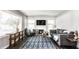 Bright living room with a stone fireplace, large window, and a geometric patterned area rug at 6491 N Oxford St, Indianapolis, IN 46220