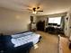 A cozy bedroom featuring carpeted flooring, a ceiling fan, and natural light from the window at 6588 Dunsdin Dr, Plainfield, IN 46168