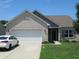 Inviting single-Gathering home featuring a two-car garage, brick facade, and manicured lawn at 7232 Moultrie Dr, Indianapolis, IN 46217