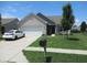 Charming one story home with white brick, manicured lawn, and an attached two car garage at 7232 Moultrie Dr, Indianapolis, IN 46217