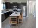 Kitchen featuring stainless appliances, dark cabinets and a seating island with adjacent doorway at 7232 Moultrie Dr, Indianapolis, IN 46217