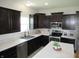Well-lit kitchen featuring stainless appliances, dark cabinets and an island with seating at 7232 Moultrie Dr, Indianapolis, IN 46217