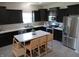 Well lit kitchen with stainless appliances, dark cabinets, and an island with seating at 7232 Moultrie Dr, Indianapolis, IN 46217