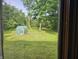 View of the lush backyard, highlighting the greenhouse and well-maintained lawn at 8423 Mud Creek Rd, Indianapolis, IN 46256