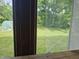 View of the backyard from a window, showcasing green grass and a greenhouse at 8423 Mud Creek Rd, Indianapolis, IN 46256