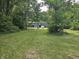 Expansive backyard with mature trees, a well-manicured lawn, and distant home view at 8423 Mud Creek Rd, Indianapolis, IN 46256