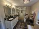 Bathroom featuring dual sinks, black countertops, a tiled shower, and modern fixtures at 8423 Mud Creek Rd, Indianapolis, IN 46256