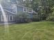 Backyard exterior featuring a well-maintained lawn and blue siding surrounded by mature trees at 8423 Mud Creek Rd, Indianapolis, IN 46256