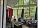 Relaxing sunroom with rustic wood pile, chimney and an array of colorful decor and natural lighting at 8423 Mud Creek Rd, Indianapolis, IN 46256