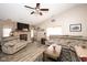 Cozy living room featuring a brick fireplace, plush seating, and a ceiling fan at 8514 Midsummer Dr, Indianapolis, IN 46239