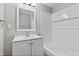 Bathroom with a single vanity, mirror, and white tiled shower and bathtub; providing a clean and modern aesthetic at 920 State St, Shelbyville, IN 46176