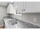 Bright kitchen featuring a stainless steel sink, modern granite counters and white cabinets with silver hardware at 920 State St, Shelbyville, IN 46176