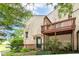 Exterior view of the back of the home, including a private deck, door to the house, and mature trees at 9552 Maple Way, Indianapolis, IN 46268