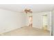 Bright bedroom featuring beige carpet, a ceiling fan, and doorways to closet and bathroom at 9552 Maple Way, Indianapolis, IN 46268