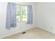 Bedroom featuring a window with curtains, carpeted floors, and neutral walls at 9552 Maple Way, Indianapolis, IN 46268