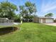 Spacious backyard with a trampoline, swing set, garage and green grass at 1039 Eastlawn Dr, Whiteland, IN 46184
