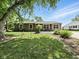 Ranch-style home showcasing a well-manicured lawn and mature trees under a bright blue sky at 1039 Eastlawn Dr, Whiteland, IN 46184