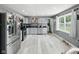 Open kitchen features gray cabinets, stainless steel appliances, and light wood flooring at 1039 Eastlawn Dr, Whiteland, IN 46184