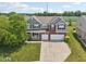 Aerial view of a two-story home with attached garage, surrounded by a green lawn and lush landscaping at 10716 Patoka Rd, Indianapolis, IN 46239