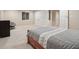 View of the basement bedroom with a bed, white closets, egress window, and a gray chair at 10716 Patoka Rd, Indianapolis, IN 46239