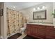 Bathroom with a shower, vanity and toilet; decorated with a palm tree shower curtain and decorative mirror at 10716 Patoka Rd, Indianapolis, IN 46239