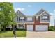 Charming two-story home with a brick and siding exterior, attached two-car garage, and well-manicured lawn at 10716 Patoka Rd, Indianapolis, IN 46239