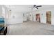 Open-concept living room featuring neutral walls, plush carpeting, and a ceiling fan for a comfortable space at 10716 Patoka Rd, Indianapolis, IN 46239