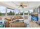 Enclosed sunroom with wicker furniture set, ceiling fan, and screen windows for natural light at 10716 Patoka Rd, Indianapolis, IN 46239