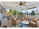 Cozy sunroom featuring wicker furniture set, ceiling fan, screen windows, and wood flooring at 10716 Patoka Rd, Indianapolis, IN 46239