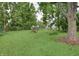 Well-maintained backyard with lush lawn, fire pit, and mature trees at 115 Northshore Blvd, Anderson, IN 46011