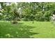 Spacious backyard featuring a fire pit area and surrounded by mature trees at 115 Northshore Blvd, Anderson, IN 46011