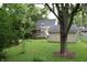 Picturesque backyard featuring a deck, mature trees, and manicured lawn at 115 Northshore Blvd, Anderson, IN 46011