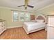 Bright bedroom featuring hardwood floors, white trim, and a ceiling fan at 115 Northshore Blvd, Anderson, IN 46011