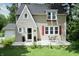 Charming home with a concrete patio, flowering plants, and red shutters at 115 Northshore Blvd, Anderson, IN 46011