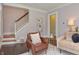 Inviting living room showcasing a comfortable armchair and staircase access at 115 Northshore Blvd, Anderson, IN 46011