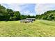Extensive backyard showcasing an above-ground pool, a white barn, and a fenced pen area at 1284 N Letterman Rd, Paragon, IN 46166