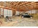 Interior view of the garage with a car, lawnmower, and other equipment with exposed wood framing at 1284 N Letterman Rd, Paragon, IN 46166
