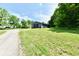 View of the gray outbuilding on a grassy lot near the street with trees at 1284 N Letterman Rd, Paragon, IN 46166