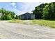 Outbuilding with gray siding and a metal roof, situated on a gravel driveway at 1284 N Letterman Rd, Paragon, IN 46166