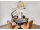 Bright dining area featuring a round table with four chairs, hardwood floors, and a modern light fixture at 12874 Tradd St, Carmel, IN 46032