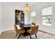 Bright dining area featuring a round table with four chairs, hardwood floors, and a modern light fixture at 12874 Tradd St, Carmel, IN 46032