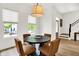 Bright dining area featuring a round table with four chairs, hardwood floors, and a modern light fixture at 12874 Tradd St, Carmel, IN 46032