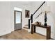 Inviting foyer with hardwood floors, staircase with black railing, stylish table, and artistic decor at 12874 Tradd St, Carmel, IN 46032