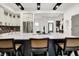 Spacious kitchen island with bar stool seating, quartz countertops, stainless steel appliances and black accents at 12874 Tradd St, Carmel, IN 46032