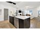 Modern kitchen featuring an island with stainless steel dishwasher, black accents, and white cabinets at 12874 Tradd St, Carmel, IN 46032