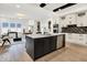 Modern kitchen featuring an island with stainless steel dishwasher, black accents, and white cabinets at 12874 Tradd St, Carmel, IN 46032